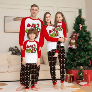 Family grinch pyjamas photo next to Christmas tree